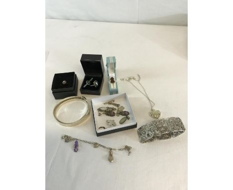 A collection of silver jewellery to include bangles, pendants with chains, Amber & silver earrings etc 