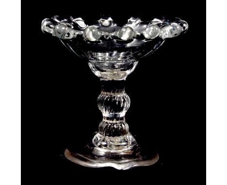 A small sweetmeat glass, slightly moulded shallow bowl with dentated rim, incised knop stem, step-domed foot (misshapen), 7cm