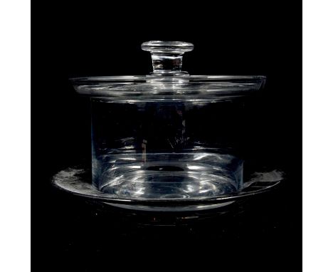 A plain circular glass butter dish and stand, of greyish metal, almost flat lid with button knop, saucer-shape stand diameter