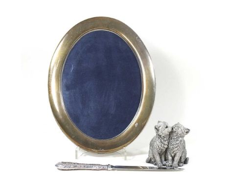 A modern silver model of two cats, shown seated, 7cm high, together with an oval silver photograph frame, 22 x 17cm and a sil