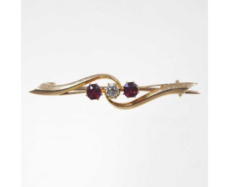 A 15 carat gold three stone diamond and ruby bar brooch, of crossover design, 3.6g, 4cm wide