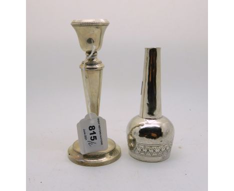 A lot comprising a silver candlestick, Birmingham 1932, 15.3cm high, weighted ( def ) with a white metal bottle vase, marked 