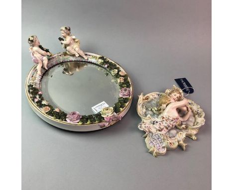 20TH CENTURY OVAL MIRROR, the mirror bevelled, the ceramic frame encrusted with foliage with two applied putti; along with a 