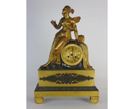 An early 19th century Empire style Ormolu figural mantle clock the 4 inch dial with ring of Roman numerals under a semi-clad 