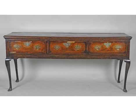 A George III oak three drawer dresser base fitted with Chippendale style brass handles raised on slender cabriole front legs 