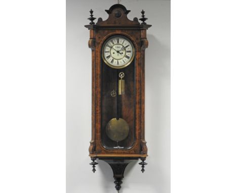 A late 19th century figured walnut Vienna style wall clock, the 7.5 inch enamel dial with ring of Roman numerals, and twin we