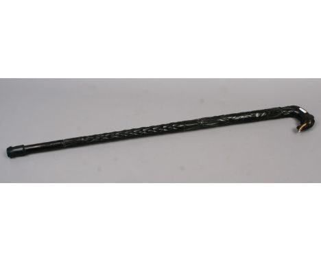 A ebonized extensively carved hardwood walking stick with elephant head handle.