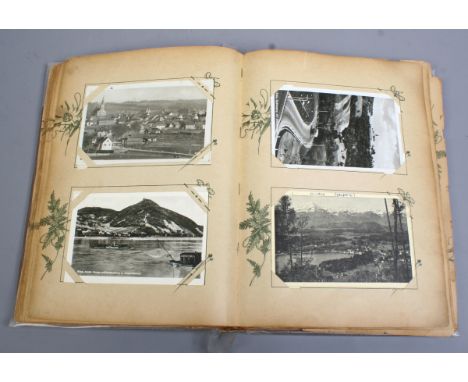 An early C20th postcard album and contents of antique cards including foreign examples, landscapes, interior scenes etc.
