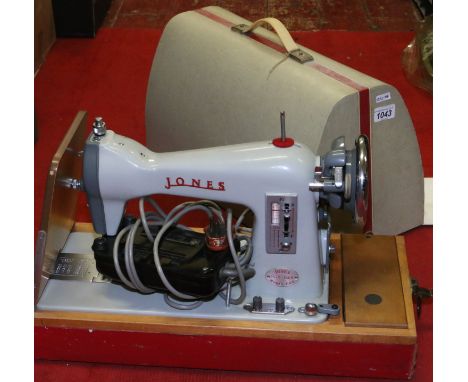 A vintage Jones electric sewing machine with pedal and instruction manual.