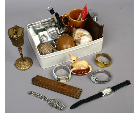 A tin of collectables including a desk lighter, wristwatches, vintage folding ruler, Beswick model of a chihuahua, Wade, carv