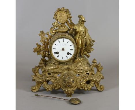 A C19th French gilt metal mantel clock, surmounted with a figure in court attire, raised on a Rococo style base and with enam