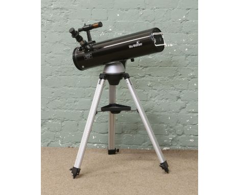 A Skywatcher telescope on tripod with instruction manual and accessories.