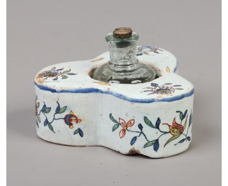 A 19th century Continental faience inkwell of trefoil shape and decorated with flower sprigs along with an associated glass i