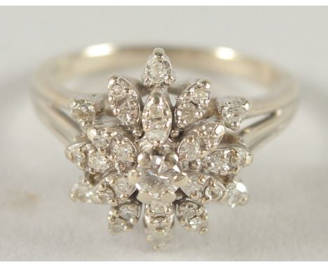 A 14CT WHITE GOLD DIAMOND CLUSTER RING.