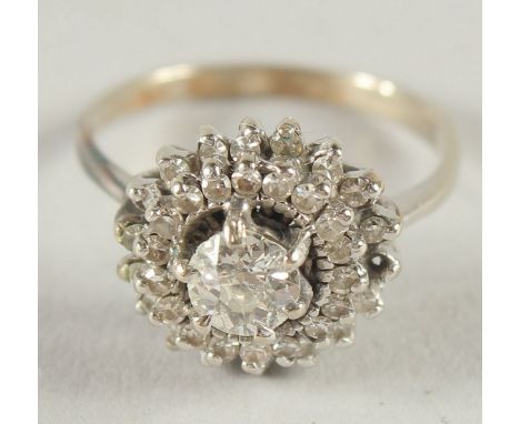 A 14CT WHITE GOLD DIAMOND CLUSTER RING.