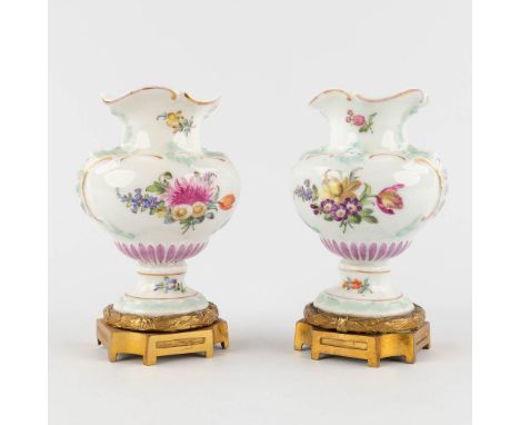 A pair of vases, polychrome porcelain with a hand-painted decor, mounted on a bronze base.19th century.&nbsp;Marked with Meis