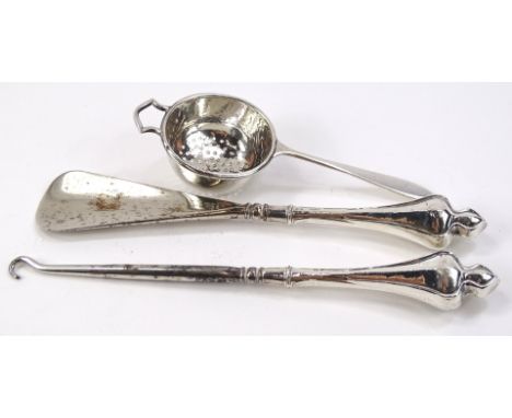 A George V silver sifter, with shaped handle and pierced bowl, Birmingham 1926, 13cm wide, a silver handle button hook and sh