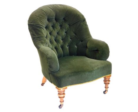 A Victorian mahogany button back armchair, upholstered in green fabric on turned legs with brass castors.