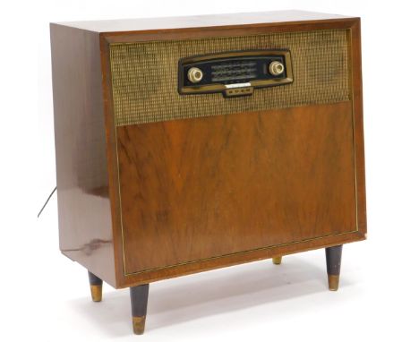 A Bush radiogram, in walnut case, the hinged front cover revealing a record player on turned table legs, 85cm wide.