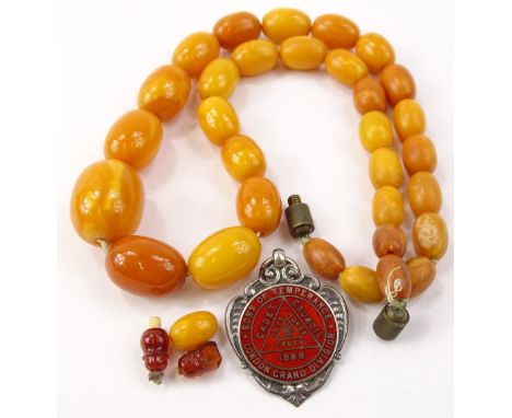 Two items of jewellery, to include a butterscotch amber beaded necklace, 33.6g all in and a silver and enamel decorated fob, 