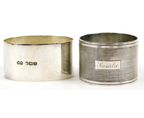 Two silver napkin rings, one circular with engraved name and engine turned decoration, the other oval, 2½oz. (2)