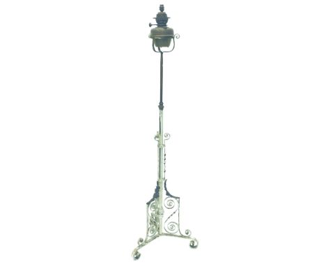 An early 20thC brass and cream painted standing oil lamp, 174cm high.