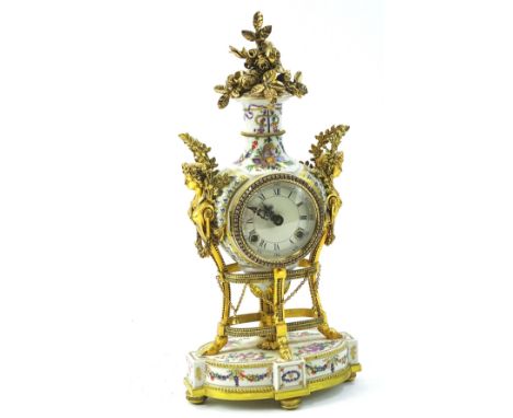 A modern rococo style mantel clock, with 10cm diameter roman numeric dial, flanked by figure handles surmounted by leaves in 