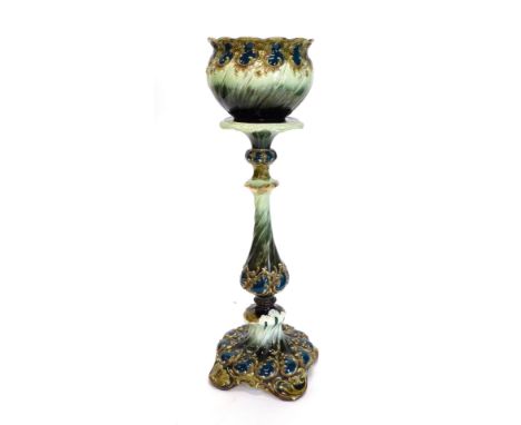 A continental pottery jardiniere and stand in the manner of Zsolnay, with Majolica coloured glazes, rococo scroll raised deco
