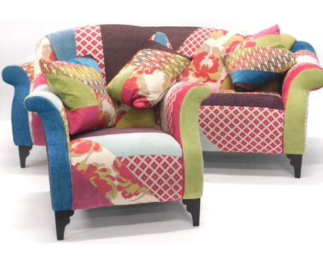 A modern sofa, upholstered in various sample type multi coloured fabrics, and a matching arm chair, each on tapering legs.