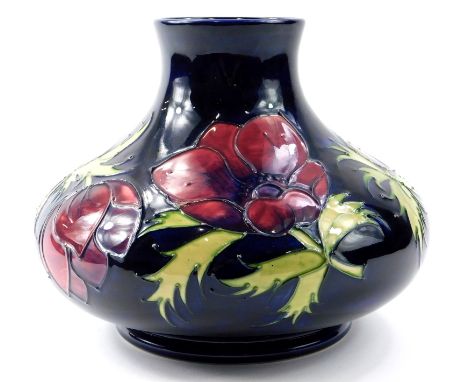 A Moorcroft pottery squat vase, decorated with anemones on a navy blue ground, impressed marks and hand written monogram to u