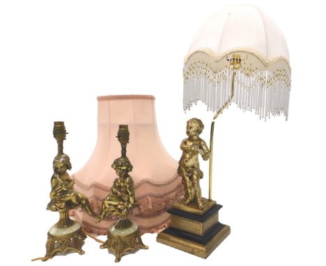 A continental table lamp, modelled in the form of a putto, on a composition base with fabric shade with glass frills, 71cm hi