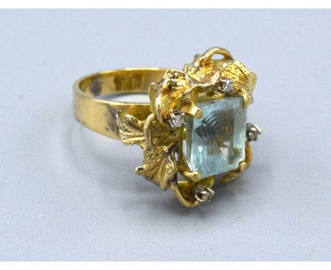 A Yellow Metal Dress Ring set with a rectangular aquamarine and four diamonds within a pierced setting 8.9 gms. ring size O 