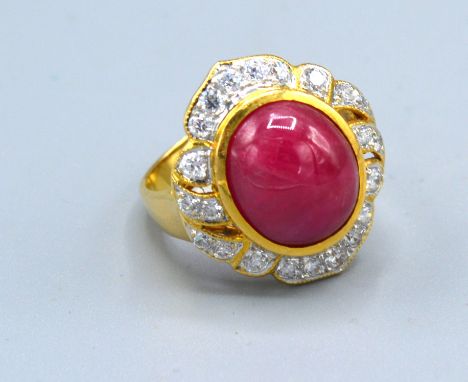 An 18ct. Gold Ruby And Diamond Ring set with a central cabochon ruby surrounded by diamonds within a pierced setting, 8.2gms.