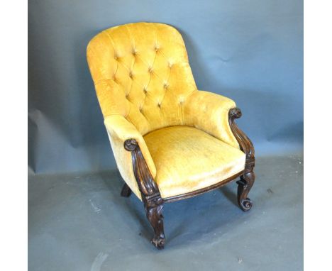 A Victorian Mahogany Drawing Room Armchair with a button upholstered back above a stuff over seat with scroll arms raised upo