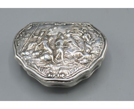An 18th/19th Century Dutch White Metal Tobacco Box of shaped form, the hinged cover decorated in relief with figures amongst 