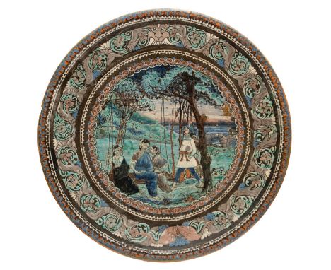A BOMBAY SCHOOL OF ART CHARGER, INDIA, CIRCA 1890, slip painted earthenware, the central scene depicting Dushyant and Shakunt