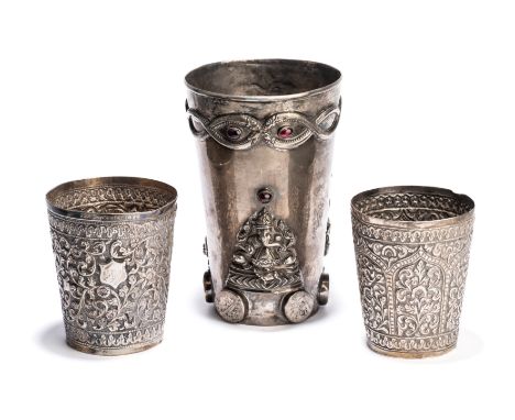 THREE SILVER BEAKERS, INDIA, CIRCA 1900, the largest South India, set with garnets, the applique decoration comprising intert