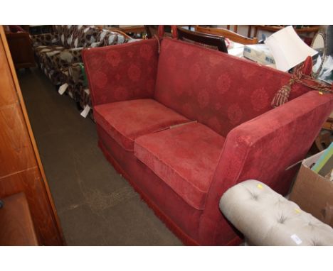 A burgundy upholstered knoll sofa