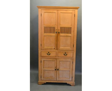A Late 19th Century Pine Housekeeper's Cupboard, the moulded cornice above two panel doors and two central drawers above furt