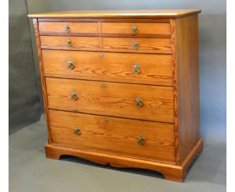 An Arts and Crafts Pitch Pine Chest with four small drawers above three graduated drawers with brass handles raised upon brac