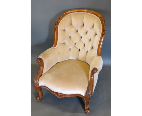 A Victorian Walnut Drawing Room Armchair, the partly carved and button upholstered back with scroll arms raised upon carved c