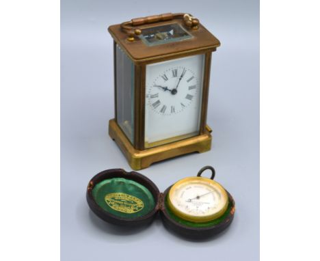 A Brass Cased Carriage Clock together with a compensated barometer by Negretti &amp; Zambra London within leather travelling 