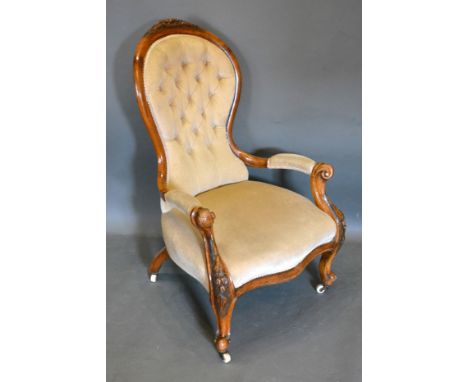 A Victorian Walnut Drawing Room Armchair, the carved shaped and button upholstered back above scroll arms and carved cabriole