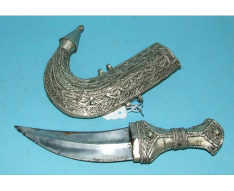 An Eastern silver coloured metal dagger, in a scabbard