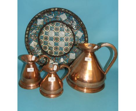 An Islamic metal charger, with enamel decoration (some loss, drilled), 47.5 cm diameter, and three copper harvest jugs (4)