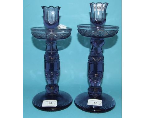 A pair of amethyst cut glass candlesticks (one cracked), 25.5 cm high