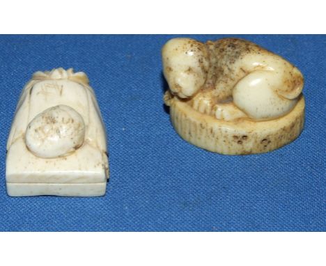 A carved bone netsuke, in the form of a dog, and another (2)