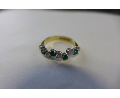 An 18ct diamond and emerald half eternity ring in an unusual stepped design, all stones approx 0.06cts, totaling 0.3cts, of d