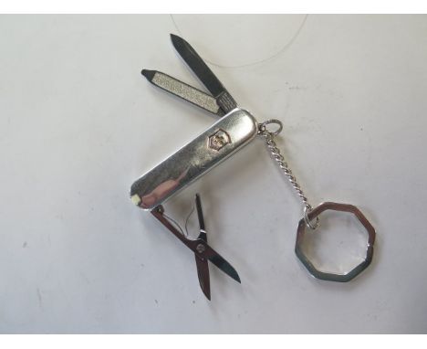 A Tiffany and Co silver and white gold penknife key ring, marked 925/750 Victorinox blade, screwdriver, file and scissors in 