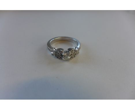 A hallmarked 18ct diamond ring, the central brilliant cut diamonds with shaped diamond encrusted shoulders, size J/K - approx